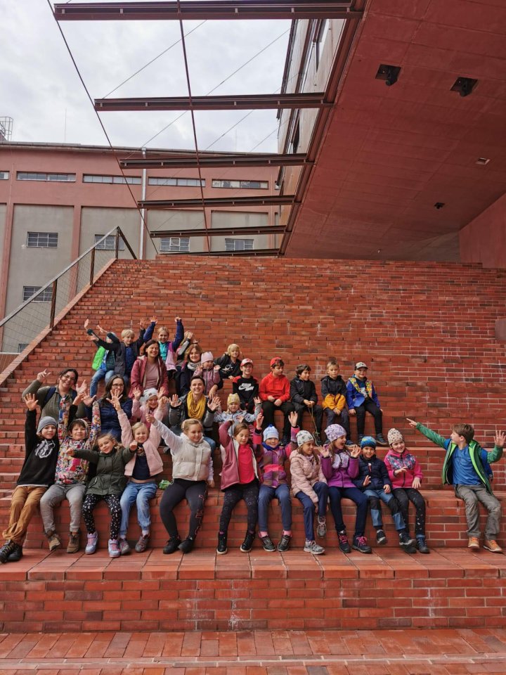 Děti na příměstském táboře ve Sféře na schodech před budovou